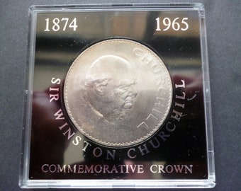 1965 Crown coin, Sir Winston Churchill in good circulated condition housed in a rigid plastic case, features the late Queen Elizabeth Second