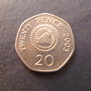 Moeda de Guernsey de 20 centavos (vinte pence) de 2003, com mapa da ilha no verso e a Rainha Elizabeth II, ideal para artesanato ou fabricação de joias.