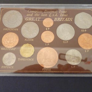 Emisión decimal completa de Gran Bretaña y últimas monedas de libra/chelín/penique alojadas en una caja de plástico rígida, 12 monedas en muy buen estado.