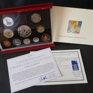 Set di nove monete Proof dell'anno 1998 della Royal Mint del Regno Unito, custodite in una custodia in vera pelle rossa della Royal Mint con un opuscolo che illustra la moneta del Principe Carlo.