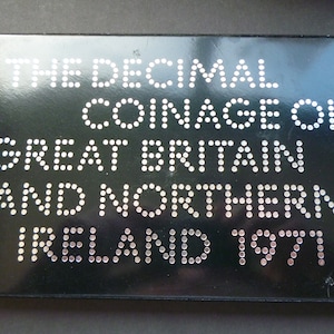 May include: Black box with silver lettering that reads "The Decimal Coinage of Great Britain and Northern Ireland 1971".