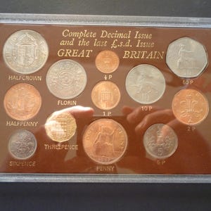 Emisión decimal completa de Gran Bretaña y últimas monedas de libra/chelín/penique alojadas en una caja de plástico rígida, 12 monedas en muy buen estado.