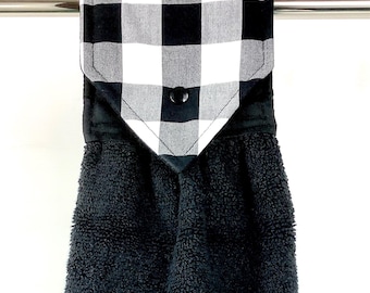 Op de afbeelding: Zwarte keukendoek met een zwart-witte buffalo plaid hanglus. De handdoek is gemaakt van een zacht, absorberend materiaal.