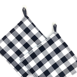 May include: Two black and white checkered kitchen pot holders with loops for hanging.
