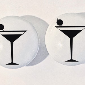 May include: Two white ceramic knobs with a black silhouette of a martini glass with an olive on the rim.