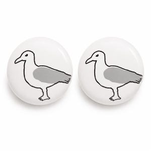 May include: Two circular white buttons, each featuring a simple black outline illustration of a seagull with a solid gray wing. The design is centered on the smooth, round surface of each button, showcasing a clean, minimalist graphic style.