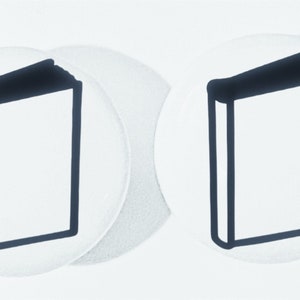 May include: Two white round stickers with black outlines of closed books on them.