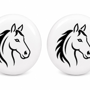 May include: Two circular white knobs featuring a black graphic illustration of a horse head in profile. The design shows the horse facing right with a stylized mane and defined facial features, centered on the smooth, glossy white surface.