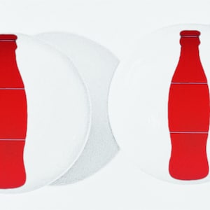 May include: Two white round coasters with a red silhouette of a soda bottle on each.