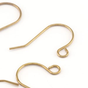 May include: Three gold-toned earring hooks, each with a curved shape and a small loop at the top.