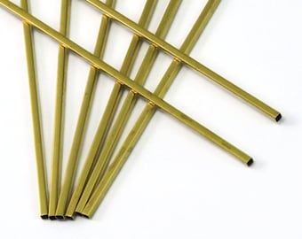 May include: A set of seven gold-colored metal rods, each with a square cross-section. The rods are arranged in a random pattern, with some overlapping.