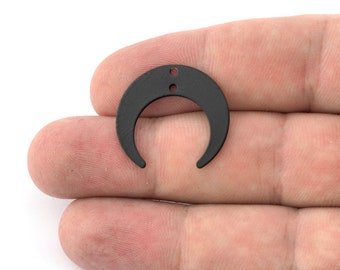 Könnte beinhalten: Ein schwarzer Metall-Halbmond-Anhänger mit zwei kleinen Löchern oben.