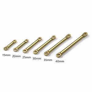 Puede incluir: Seis conectores de metal de latón de diferentes longitudes, que van desde 15 mm hasta 40 mm. Cada conector tiene un agujero en cada extremo. Los conectores están dispuestos en una fila, el más corto a la izquierda y el más largo a la derecha.
