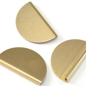 May include: Three gold-colored metal half-circle shapes. Two of the shapes are flat, and one has a rolled edge.