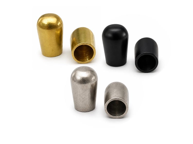 Raw brass, light antique silver and black painted metal end caps for 9mm leather cord on white background