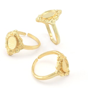 Puede incluir: Tres anillos de color dorado con un bisel ovalado. Los anillos son ajustables y tienen un diseño delicado y ornamentado.