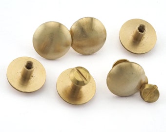 May include: Six brass dome-shaped screw-on fasteners with a flat base. The fasteners have a threaded post and a flat head.