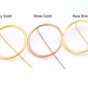 May include: Three circular hoop earrings in different finishes: shiny gold, rose gold, and raw brass. Each hoop has a straight wire attached to the side.