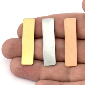 May include: Three rectangular metal sheets in gold, silver, and copper.