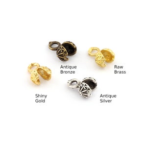 Puede incluir: Cuatro tapones metálicos para la fabricación de joyas en diferentes acabados: bronce antiguo, latón en bruto, oro brillante y plata antigua.