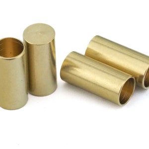 May include: Four gold-colored metal tubes, each with a smooth, cylindrical shape. The tubes are arranged in a group, with two tubes lying horizontally and two tubes standing vertically.