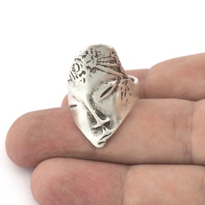 Peut inclure: Une bague en argent avec un design d&eacute;taill&eacute; d'un visage. Le visage est sculpt&eacute; en 3D et pr&eacute;sente un design d&eacute;taill&eacute; des cheveux et des yeux.