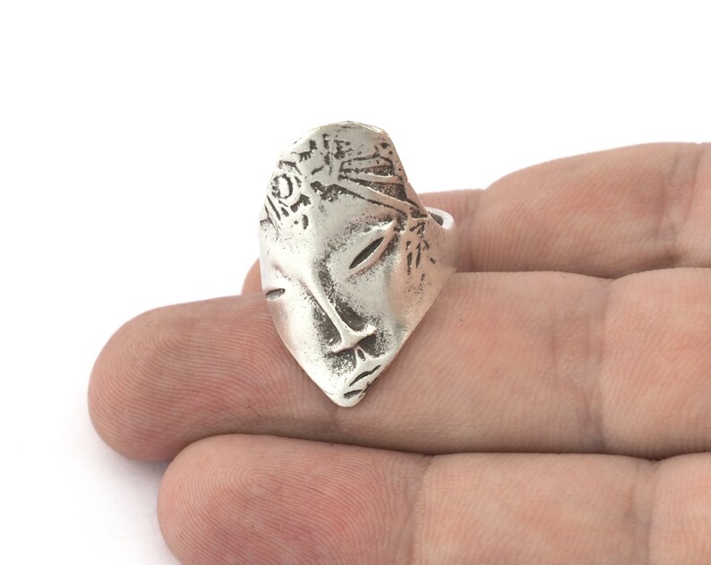 Peut inclure: Une bague en argent avec un design d&eacute;taill&eacute; d'un visage. Le visage est sculpt&eacute; en 3D et pr&eacute;sente un design d&eacute;taill&eacute; des cheveux et des yeux.