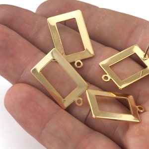 Peut inclure: Quatre apprêts de boucles d'oreilles en métal doré de forme rectangulaire avec une petite boucle en haut. Les apprêts sont conçus pour être remplis de résine ou d'autres matériaux.