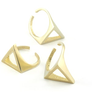 Puede incluir: Tres anillos de oro en forma de triángulo. Los anillos son abiertos y se pueden ajustar para que quepan en diferentes tamaños de dedos.