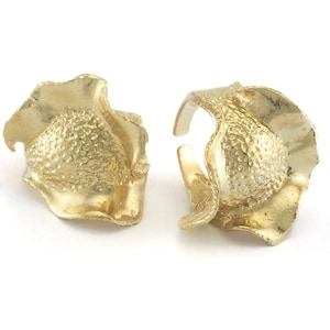 May include: Two gold-toned rings with a textured, organic, and asymmetrical design. The rings are made of metal and have a unique, modern aesthetic.