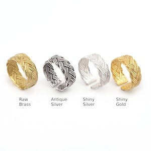 May include: Four braided rings in different finishes: raw brass, antique silver, shiny silver, and shiny gold.