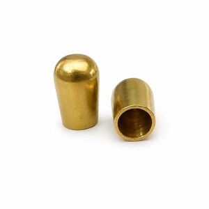 Raw brass cord end cap for 9mm round leather cord with rounded dome shape on white background