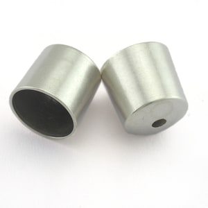 May include: Two silver metal caps with a small hole in the bottom of each cap.