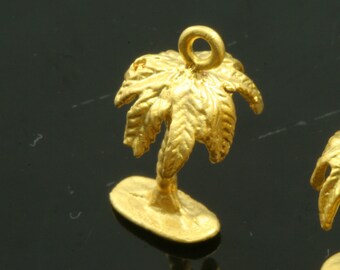 May include: Gold palm tree charm with a loop at the top for attaching to jewelry or other crafts.