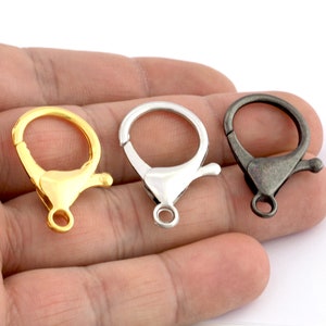 May include: Three metal lobster clasps in gold, silver, and black.