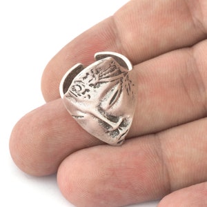 Peut inclure: Une bague en argent avec un design d&eacute;taill&eacute;, ressemblant &agrave; un visage ou un masque stylis&eacute;. La bague est ouverte d'un c&ocirc;t&eacute;, ce qui sugg&egrave;re qu'elle est ajustable.