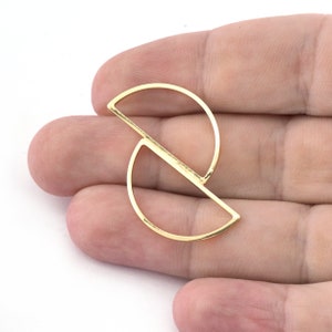 Può includere: Orecchino geometrico in metallo dorato con un design a semicerchio.