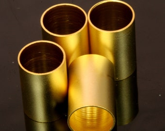 May include: Four gold-colored metal tubes stacked on top of each other. The tubes are smooth and shiny, with a slightly textured surface.
