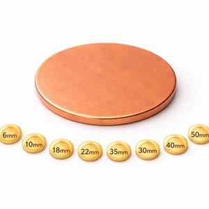May include: A circular copper-coloured lid with a brushed finish, alongside eight small, gold-coloured circular pieces. Each piece is labelled with a millimetre measurement: 6mm, 10mm, 18mm, 22mm, 35mm, 30mm, 40mm, and 50mm.