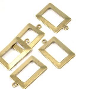 May include: Four gold-toned metal picture frame charms with a loop at the top for hanging. The frames are rectangular with a smooth, slightly textured surface.