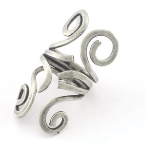 May include: A silver ring with a unique, abstract design featuring multiple intertwined swirls.