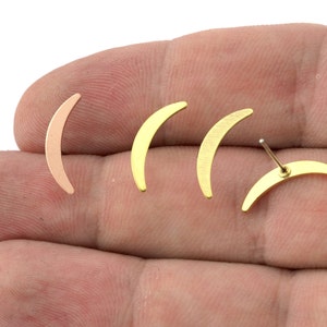 May include: Three crescent moon shaped earrings, one is rose gold and the other two are gold.