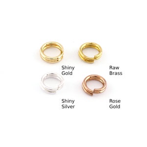 Op de afbeelding: Vier springringen in verschillende afwerkingen: glanzend goud, ruw messing, glanzend zilver en rosé goud.