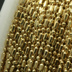 May include: A close-up of a gold chain with alternating round and rectangular links. The chain is made of metal and has a shiny finish.