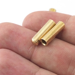 Può includere: Due tubi di metallo color oro, forse per la creazione di gioielli o artigianato.