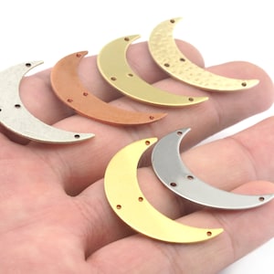 Puede incluir: Seis abalorios de metal en forma de media luna en diferentes colores y acabados. Los abalorios son plateados, dorados, cobrizos y dorados martillados. Cada abalorio tiene tres pequeños agujeros.