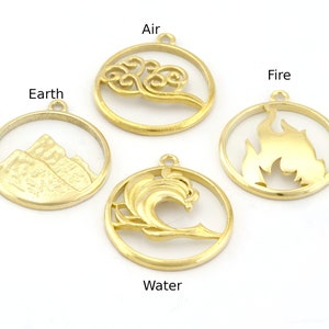 Może przedstawiać: Cztery złote metalowe zawieszki, każda w okrągłej ramce. Zawieszki reprezentują elementy: Ziemię (góry), Powietrze (chmury), Ogień (płomienie) i Wodę (fala). Każda zawieszka ma małą pętlę.