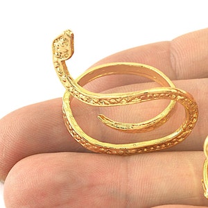 Op de afbeelding: Een goudkleurige slangenring met een opgerold ontwerp. De ring heeft een getextureerd oppervlak en een verhoogde slangenkop. Een uniek sieraad.