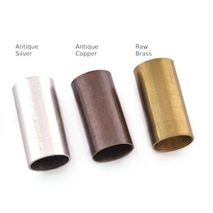 May include: Three metal tubes in different finishes: antique silver, antique copper, and raw brass. The tubes are all the same size and shape, and they are arranged in a row from left to right.