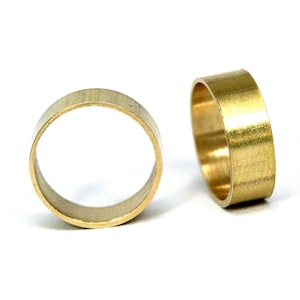 May include: Two gold-colored metal rings, one lying flat and the other standing upright.